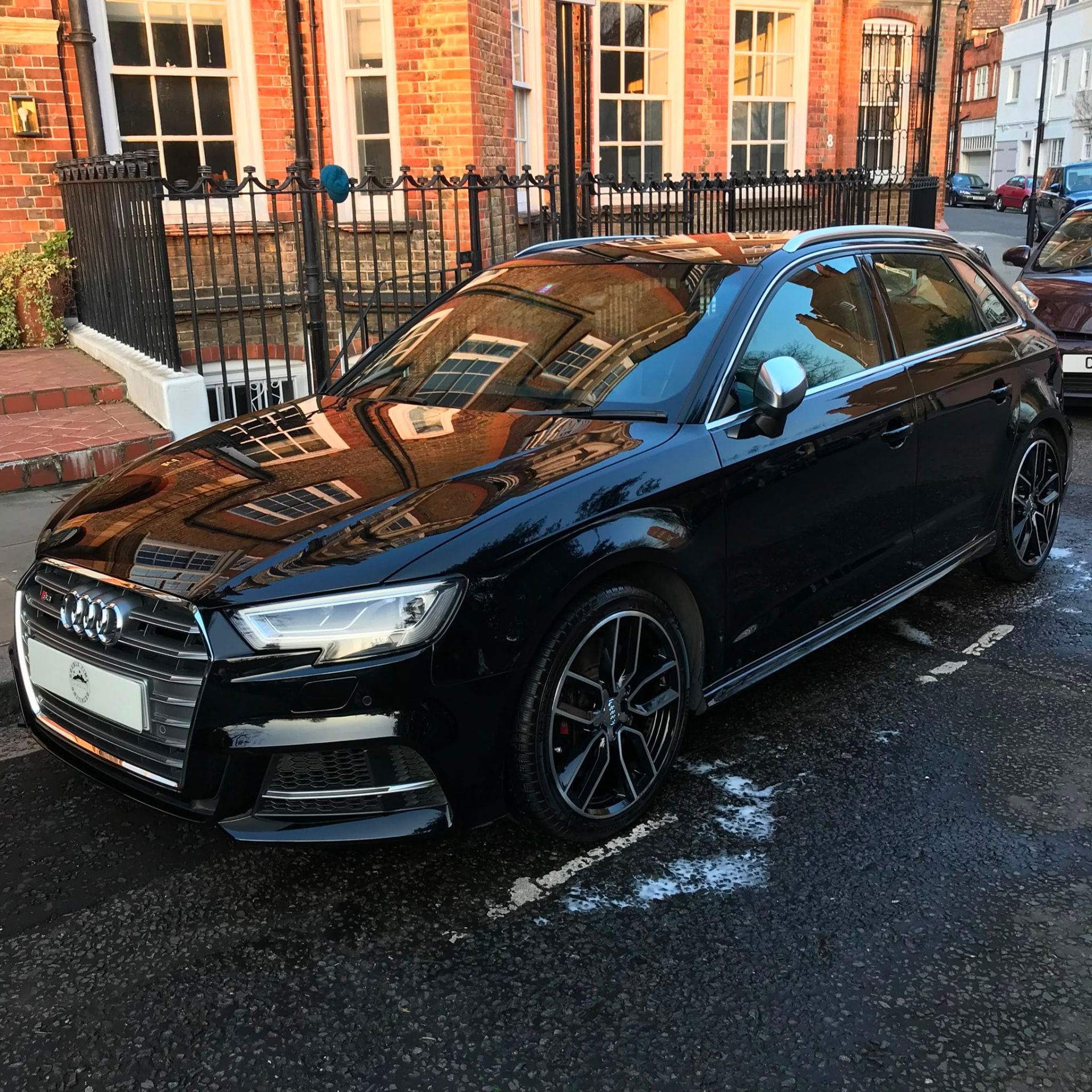 Black Audi S3 detailed to a mirror shine on a London street